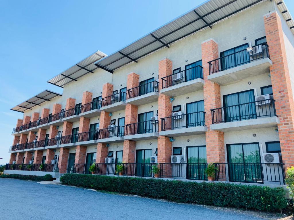 ein Apartmenthaus mit Balkon auf einer Straße in der Unterkunft 168Pattana in Ban Nong Pho