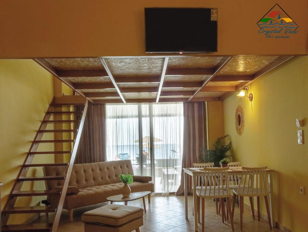 a living room with a couch and a tv on the ceiling at Crystal View - Elsa's Apartments in Kavála