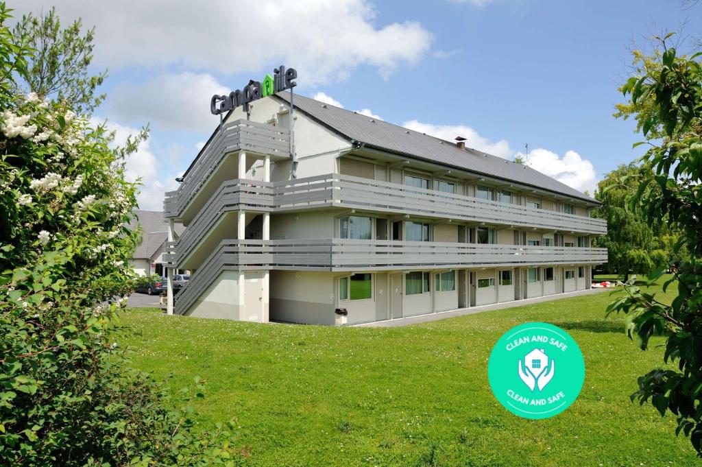 un bâtiment avec un panneau vert devant lui dans l'établissement Campanile Pont-à-Mousson, à Pont-à-Mousson