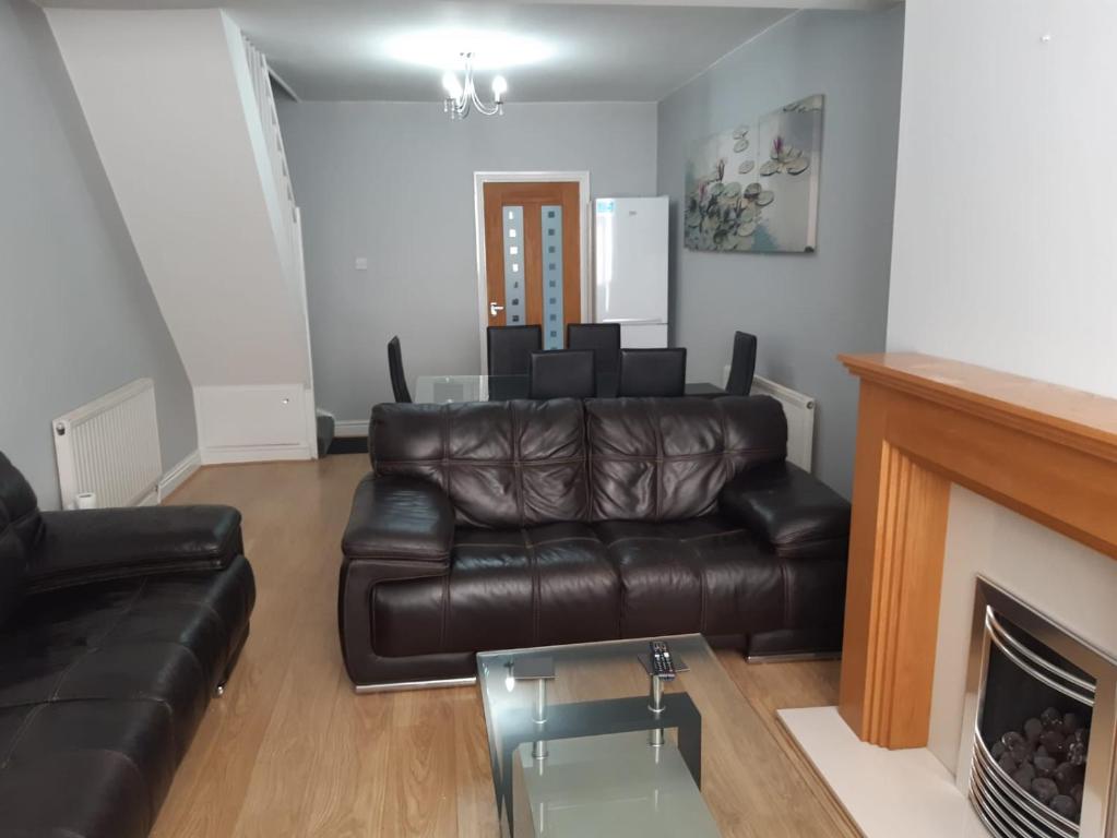 uma sala de estar com um sofá de couro e uma lareira em Hanwell House em Liverpool