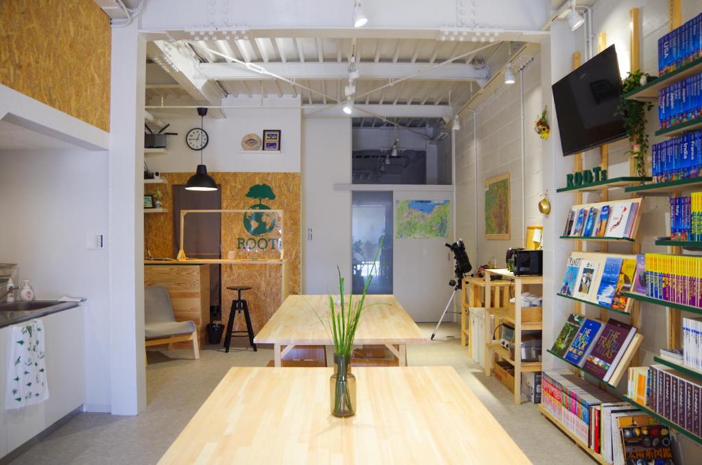 een kamer met een tafel en boekenplanken bij Travelers' house ROOTs in Takaoka