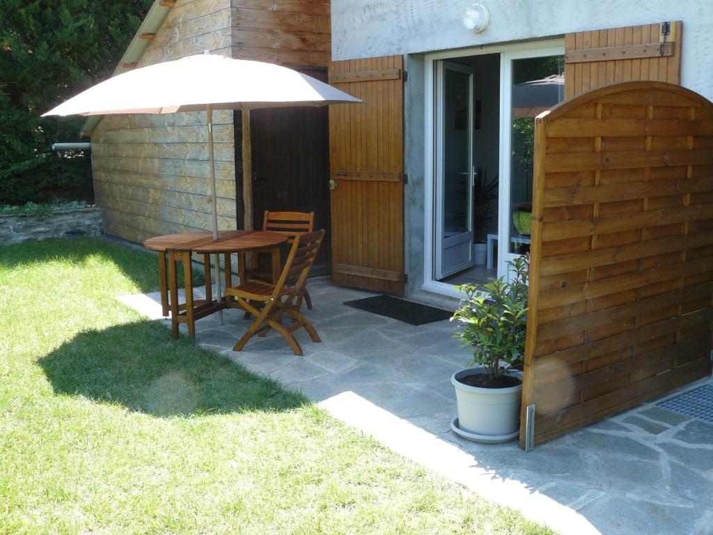 a table and chairs under an umbrella on a patio at STUDIO ENTRE SAVINES ET EMBRUN PRES DU LAC DE SERREPONçON in Crots