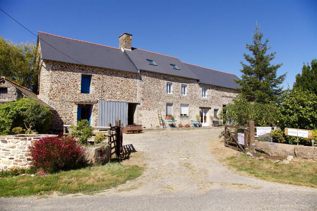 une grande maison en briques avec une clôture devant elle dans l'établissement La Petite Chesnee, à Sacey