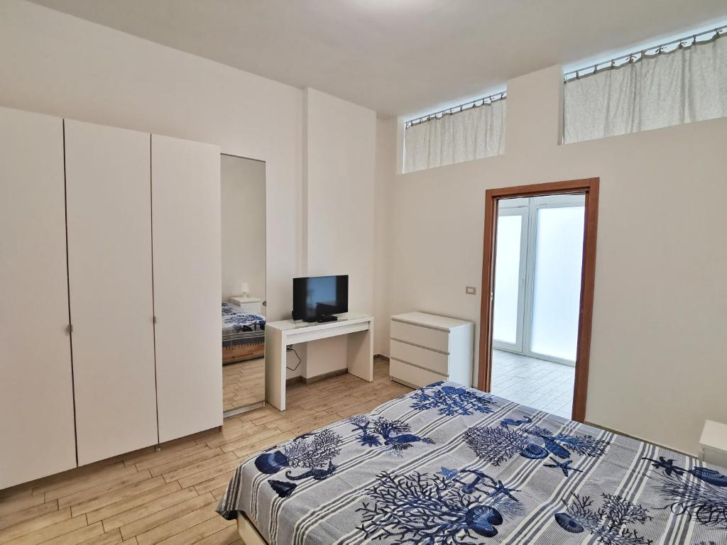 ein Schlafzimmer mit einem Bett und einem TV. in der Unterkunft All' Ombra del Faro - Mini Apartments in Taranto
