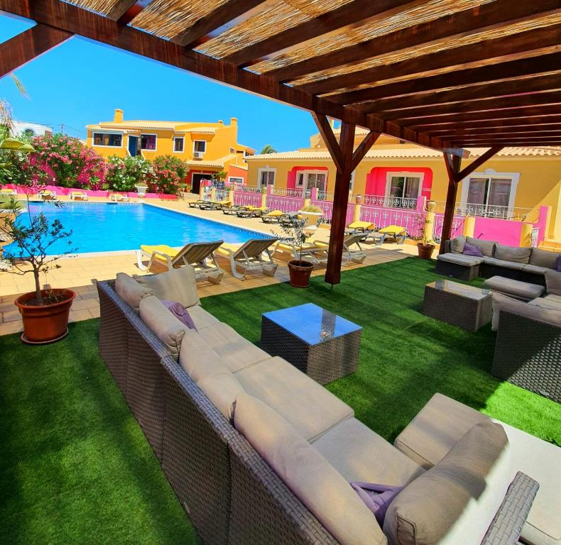 an outdoor patio with a couch and a swimming pool at Vila Graciosa - Tranquility Oasis in Lagos