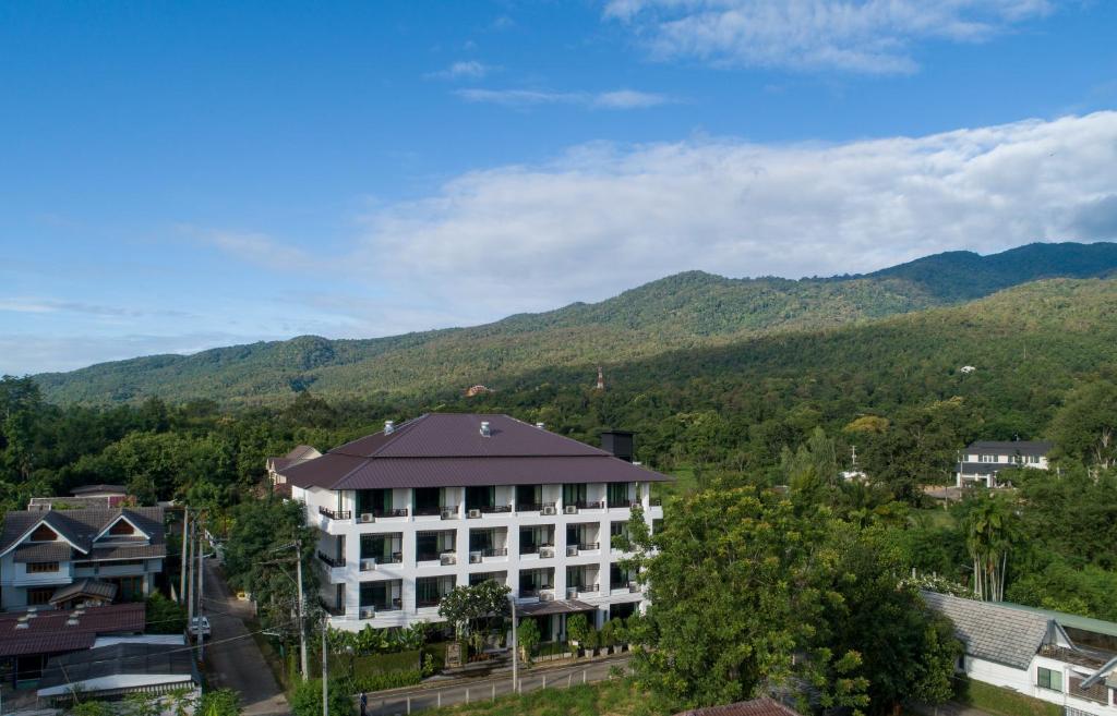清邁的住宿－桑寧靜旅館，享有背景山景建筑的景致。