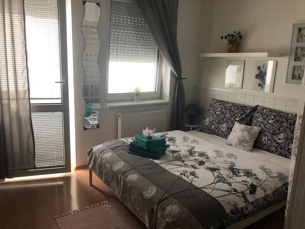 ein Schlafzimmer mit einem Bett und zwei Fenstern in der Unterkunft Apartment Sofia with terrace & parking in Bratislava