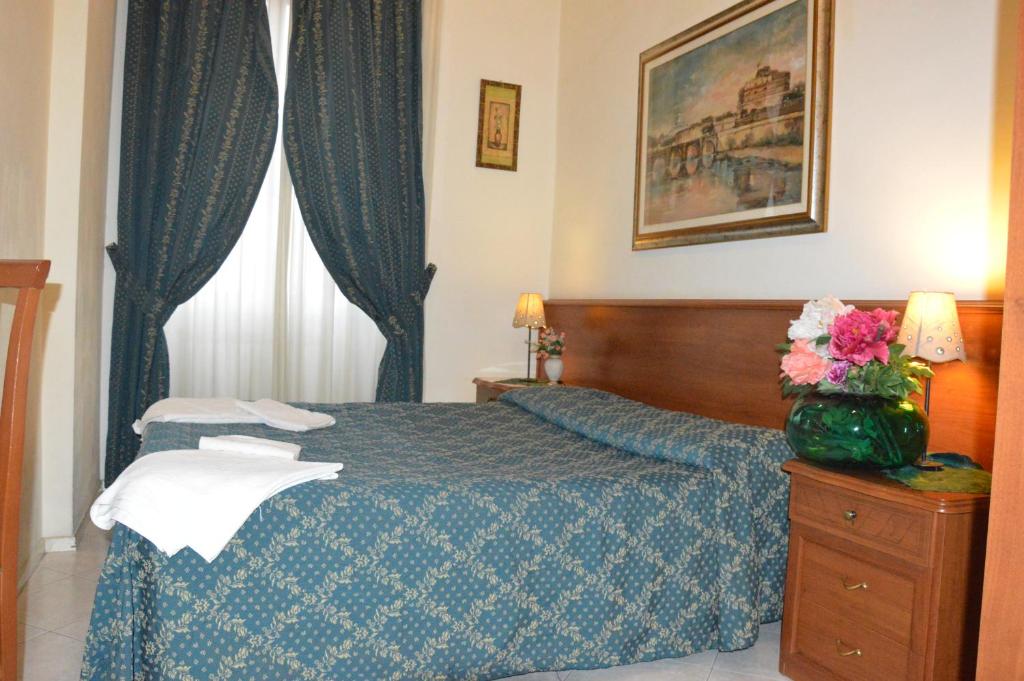 sypialnia z niebieskim łóżkiem i oknem w obiekcie Alloggio Turistico w Rzymie