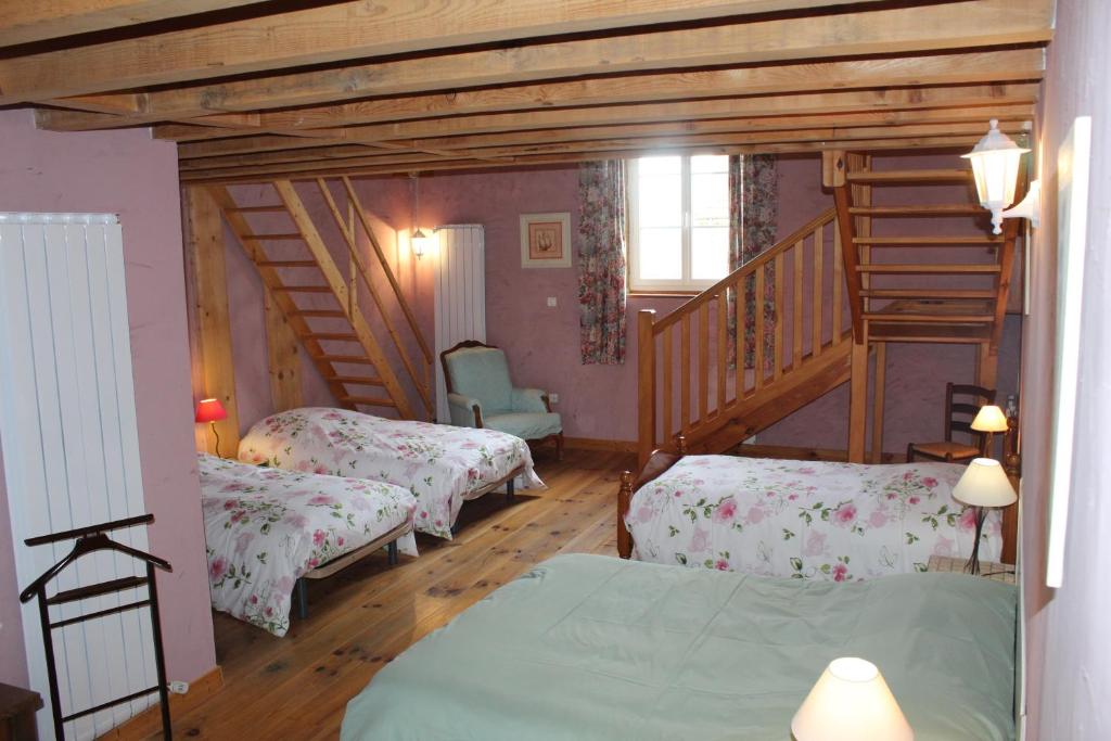 a bedroom with two beds and a staircase at COMME UN COQ EN PÂTE in Bourg-le-Comte