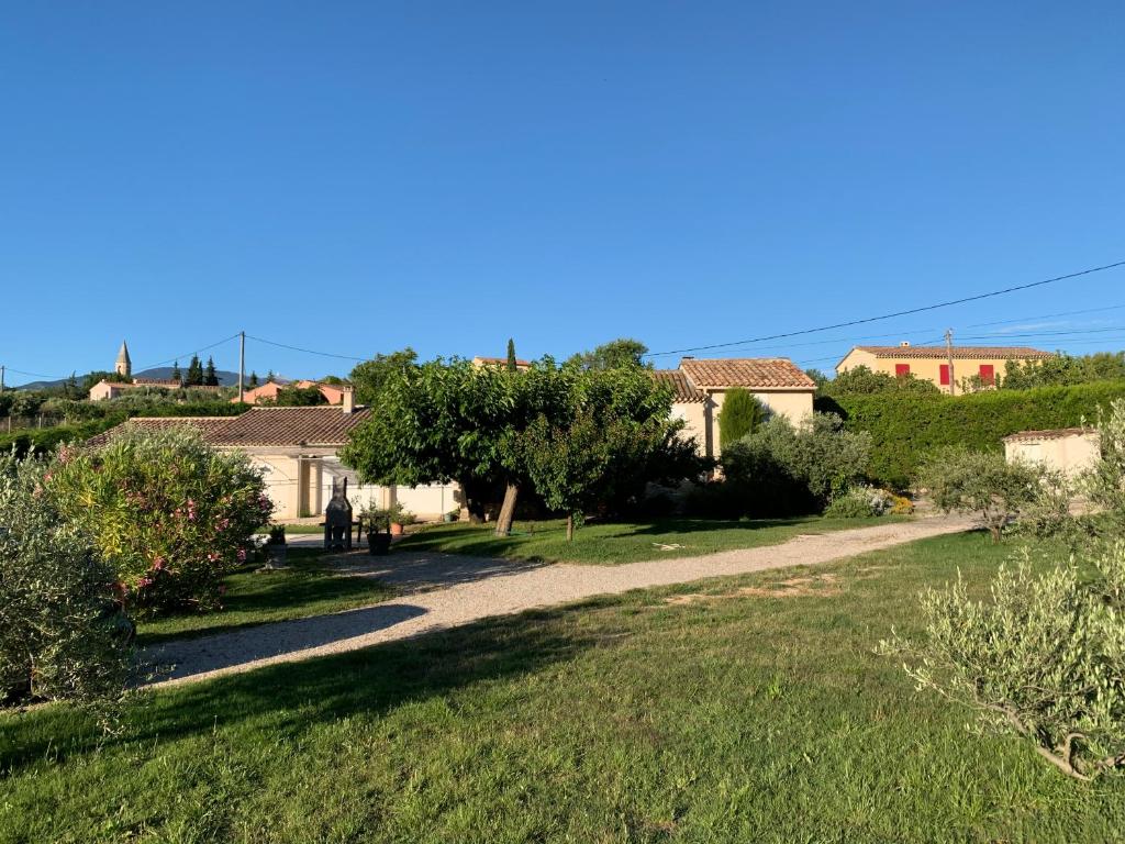 un chemin à travers un jardin avec des maisons en arrière-plan dans l&#39;établissement Le Mazet Des Joncs en Provence, à Saint-Pierre-de-Vassols