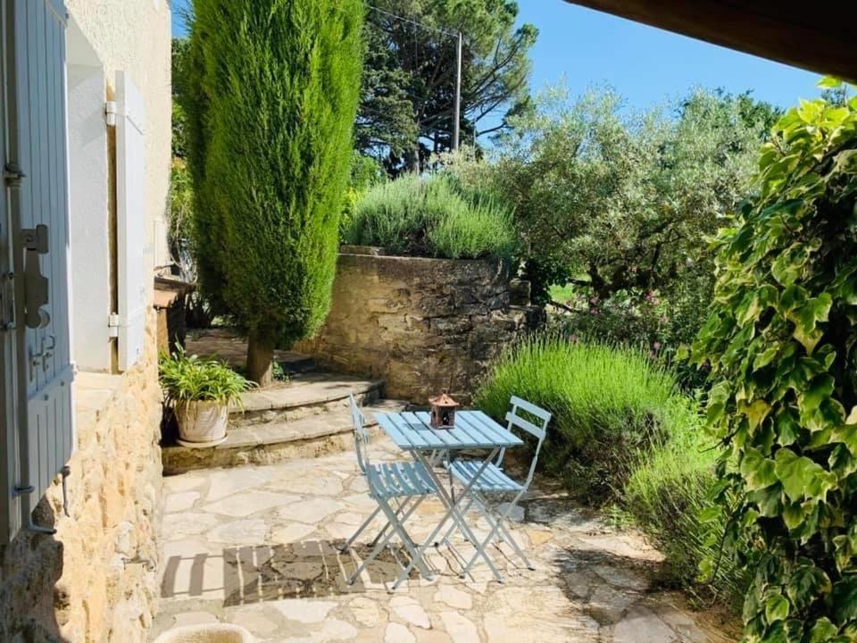 d&#39;une terrasse avec une table et des chaises dans le jardin. dans l&#39;établissement Le Mazet Des Joncs en Provence, à Saint-Pierre-de-Vassols