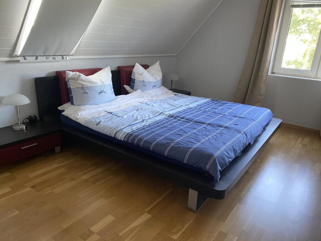 a bed with a blue comforter and pillows in a bedroom at MeinJork in Jork