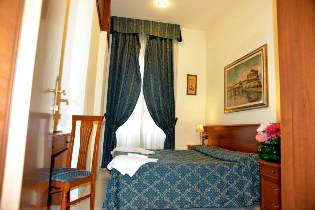 sypialnia z łóżkiem i oknem z zasłonami w obiekcie Alloggio Turistico w Rzymie