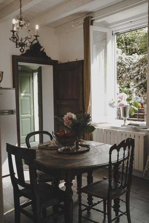 a dining room table with a vase of flowers on it at Il Giardino Segreto Arona, Charming Apartments in Arona