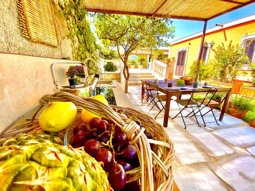 einen Korb mit Obst und Gemüse auf einer Terrasse in der Unterkunft Nido al Lido in Noto