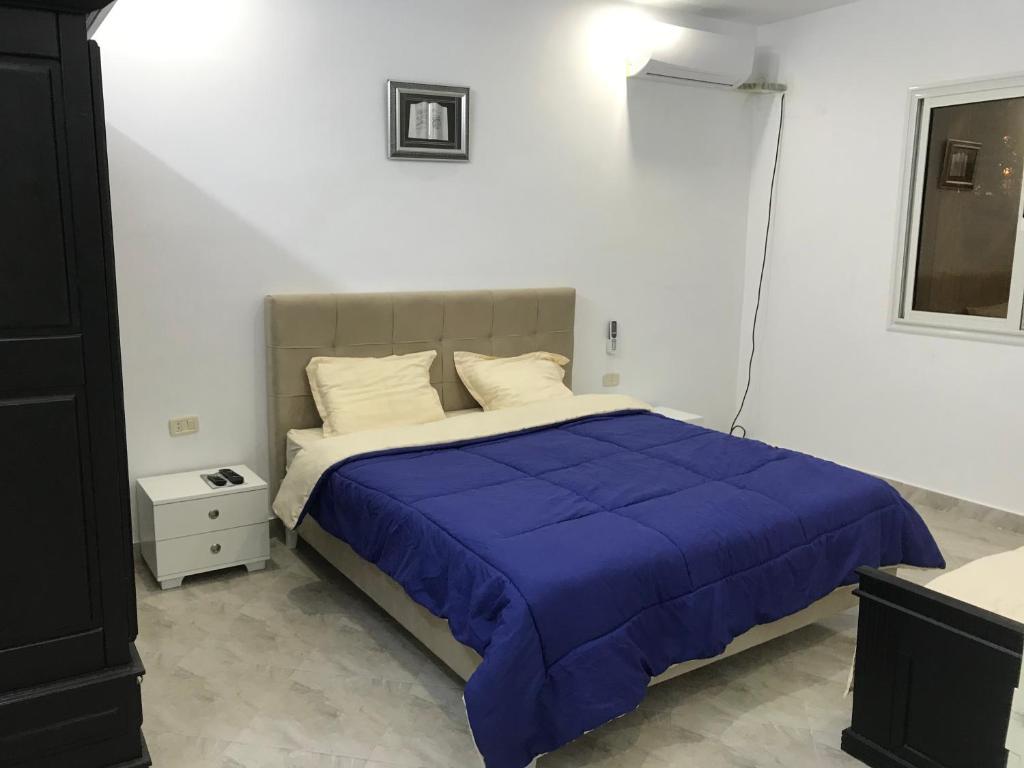 a bedroom with a large bed with a blue comforter at Maison de Vacances Tazarka in Tazarka