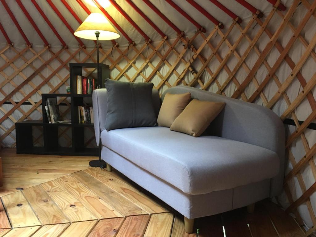 a couch in a yurt with a table and a lamp at Moulin de la Buade in Termes