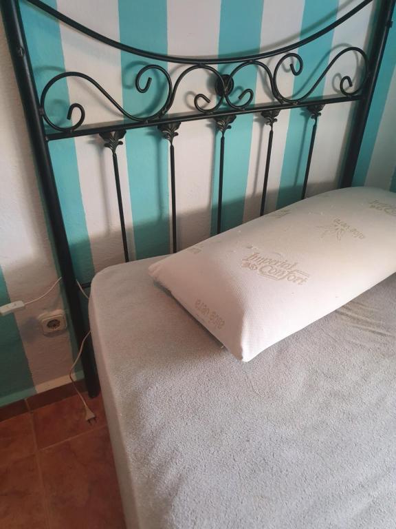 a black bed with a white pillow on it at Casa mari carmen in Almuñécar