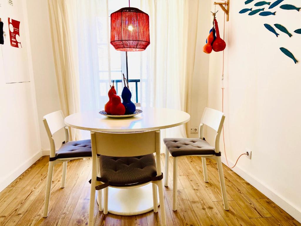 een eettafel met stoelen en een lamp bij Enjoy Casa dos Corvos Apartment in Lissabon