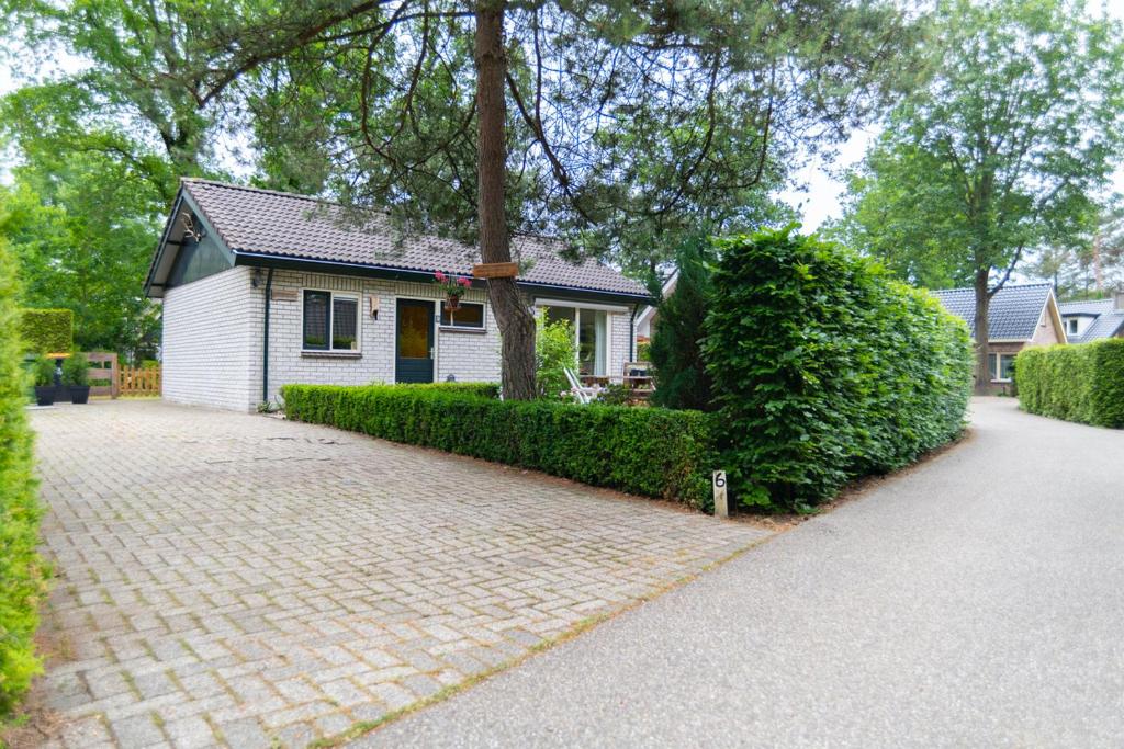 une maison avec une allée en briques en face d'une maison dans l'établissement Vakantiehuisje Specht, à Otterlo