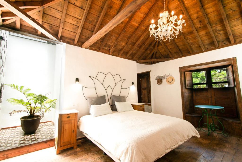 a bedroom with a large bed and a chandelier at Casa 1820 by Rural La Palma in Santa Cruz de la Palma