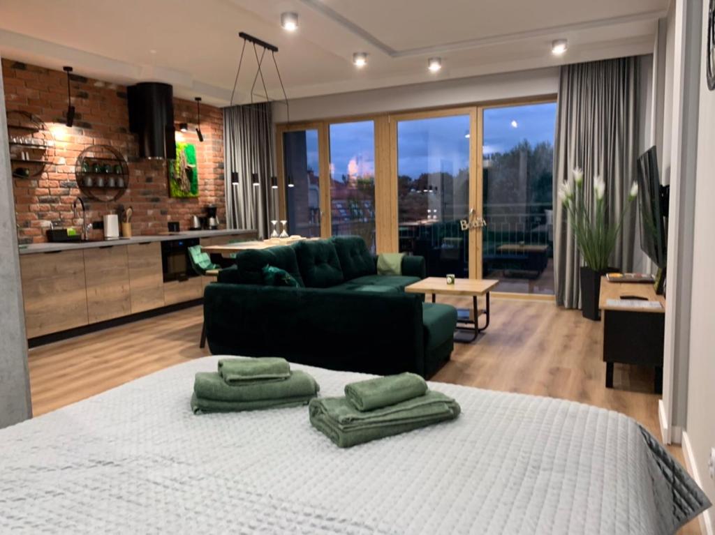 a living room with a large bed with green pillows on it at Marina Green Loft in Ełk