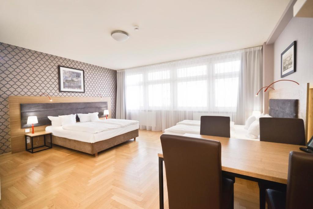 um quarto com uma cama, uma mesa e uma sala de jantar em AMC Apartments Ku'damm & Bundesallee em Berlim