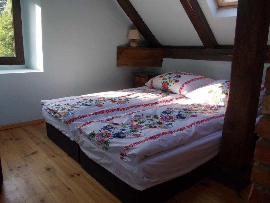 Una cama con edredón en un dormitorio en Wiśniowy Młyn en Wiśniowa