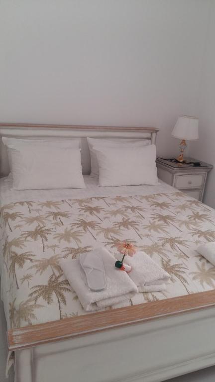 Una cama con una toalla y una muñeca. en NN Luxury Apartment near Athens airport, en Spáta