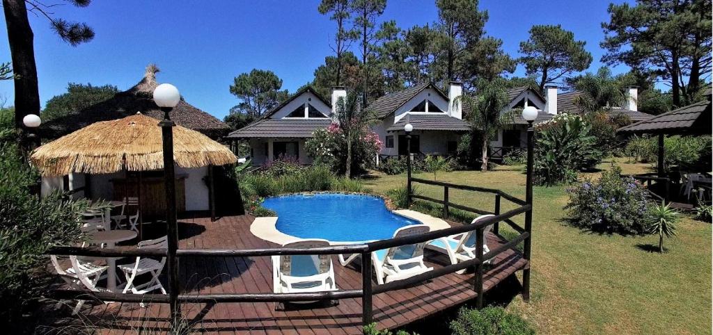 a house with a swimming pool in the yard at Bungalows Punta Colorada in Piriápolis