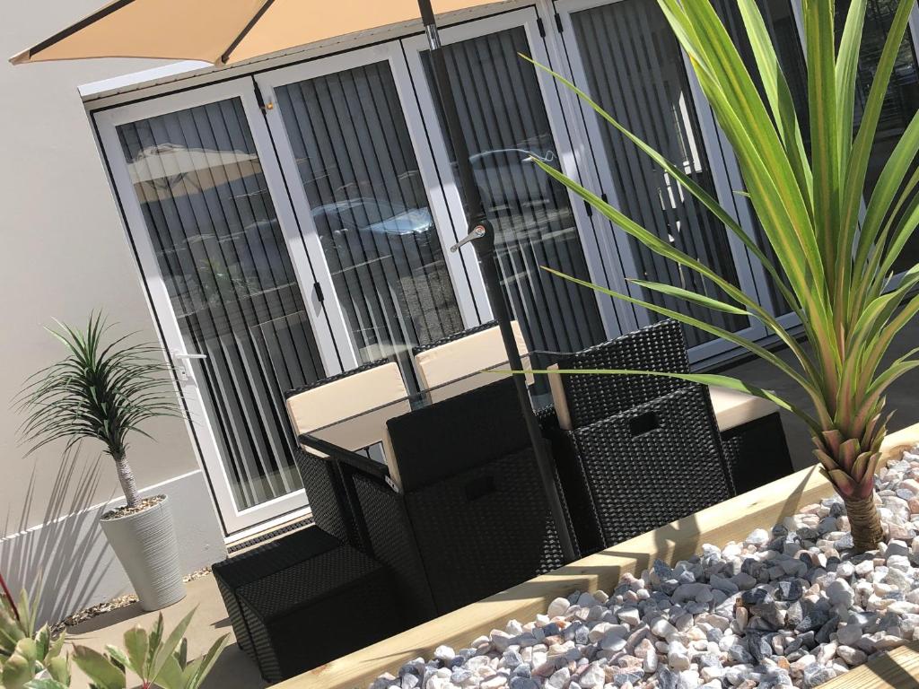 eine Terrasse mit Stühlen und einem Sonnenschirm auf dem Balkon in der Unterkunft Annexe@No8 in Haverfordwest