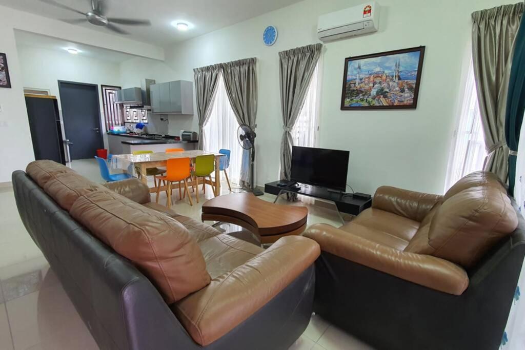 ein Wohnzimmer mit einem Ledersofa und einem Tisch in der Unterkunft Mawah Qaseh@the Park in Labu