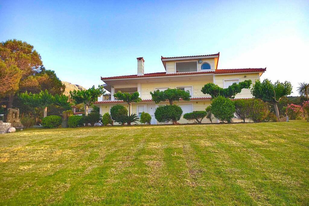 a large house with a large yard in front of it at Villa Aegean in Mourteri
