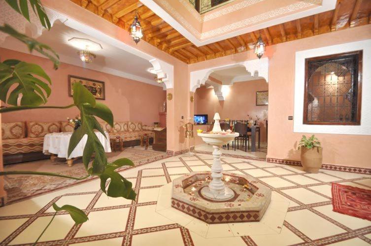 un vestíbulo con una fuente en medio de una habitación en Riad La Famille, en Marrakech