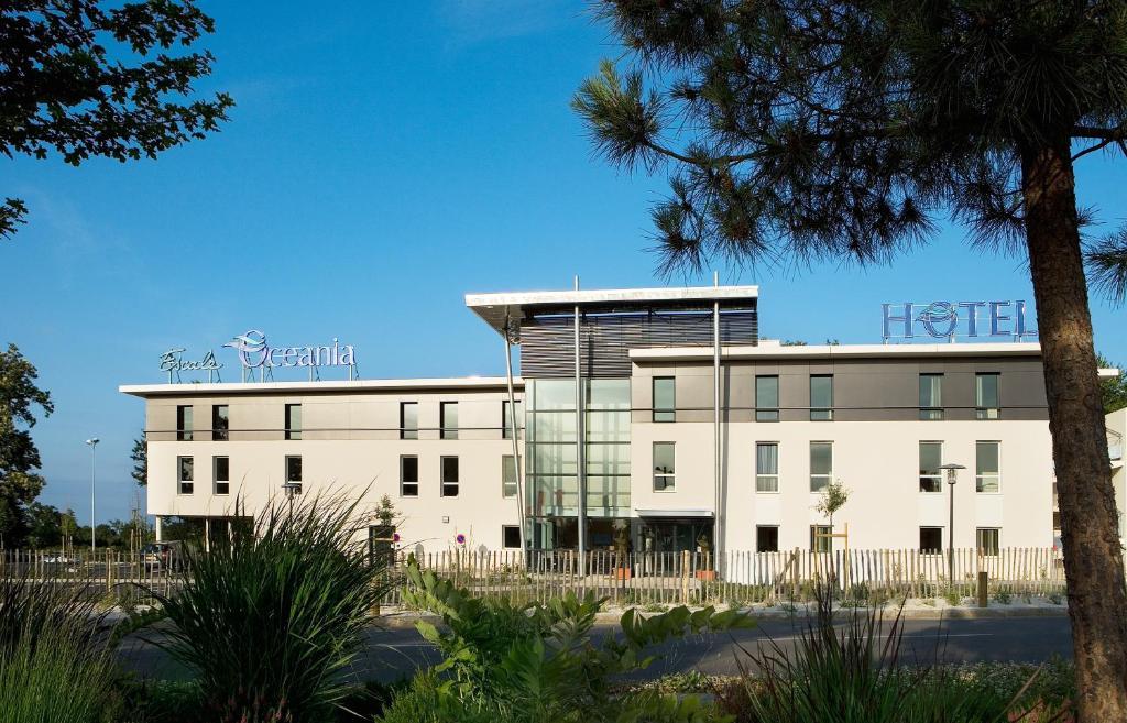 a white building with a sign on top of it at Escale Oceania Rennes Cap Malo in La Mézière