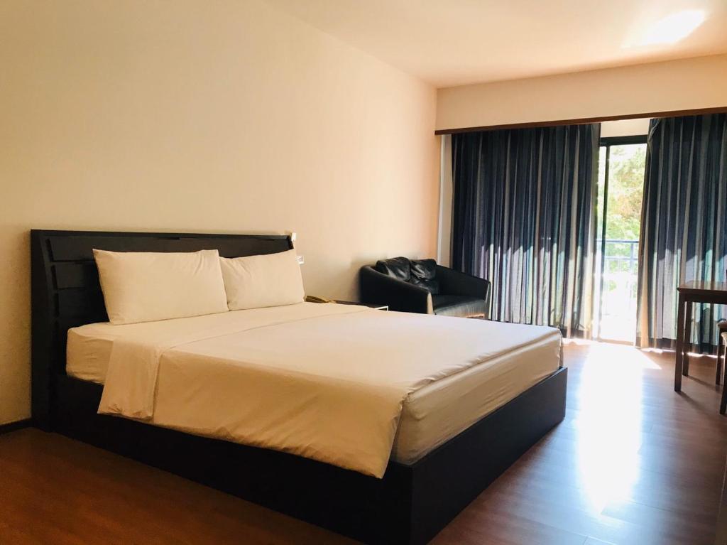a bedroom with a bed and a large window at Baan Khun Nine in Pattaya Central