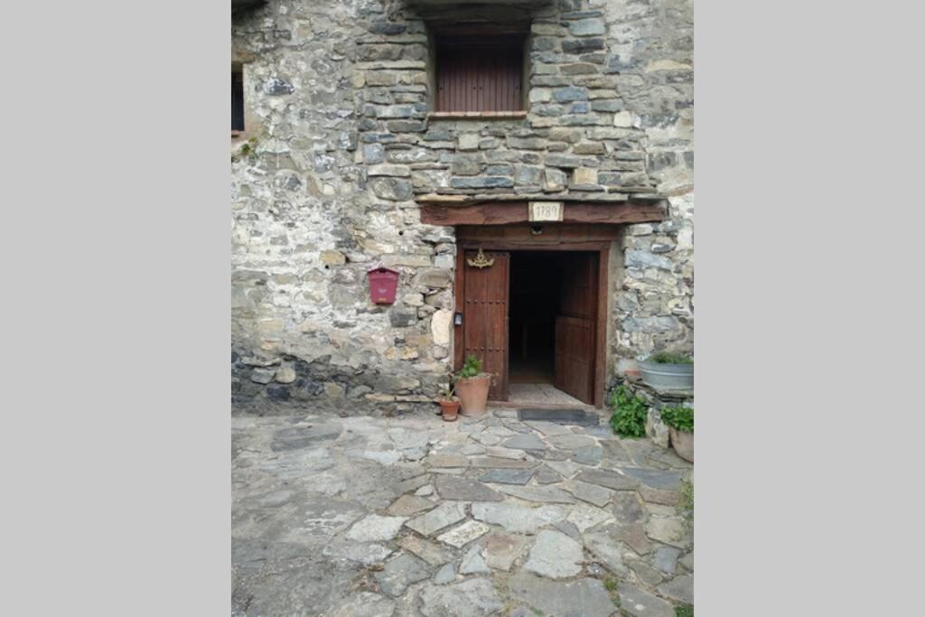 ein Steingebäude mit einer Tür und einem Fenster in der Unterkunft Lugares Comunes. Poyales. in Poyales