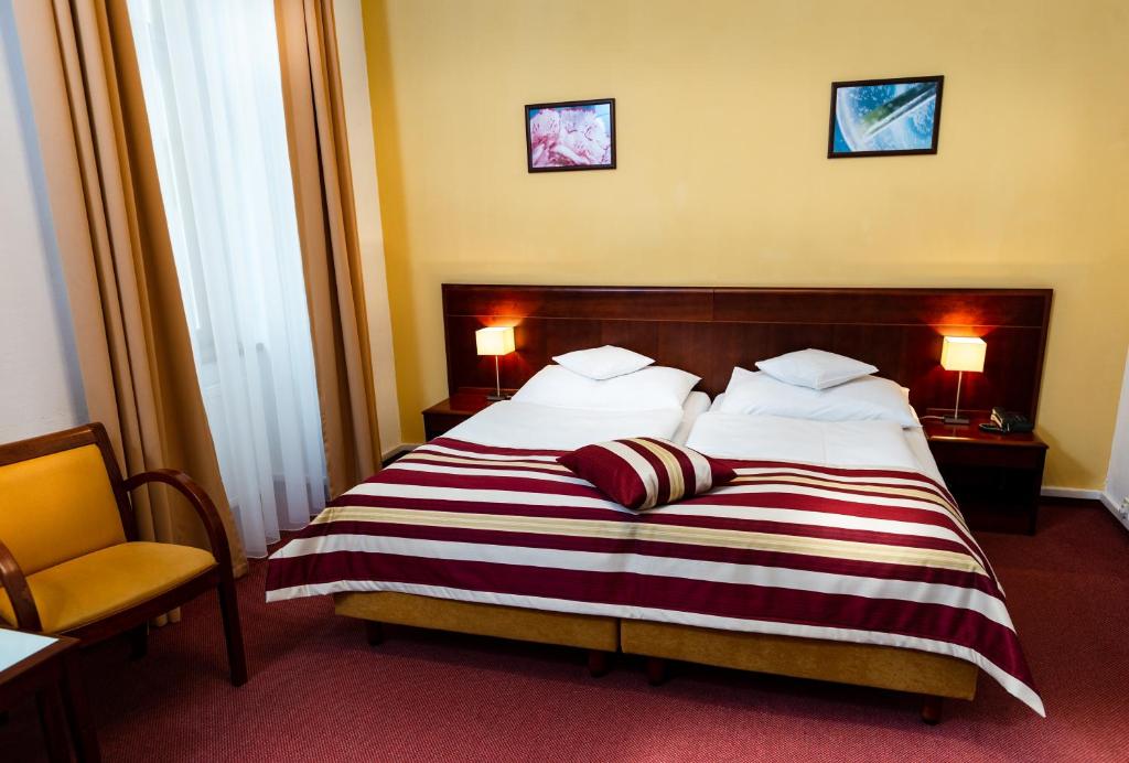 a hotel room with a bed with a striped blanket at Hotel Petr in Prague