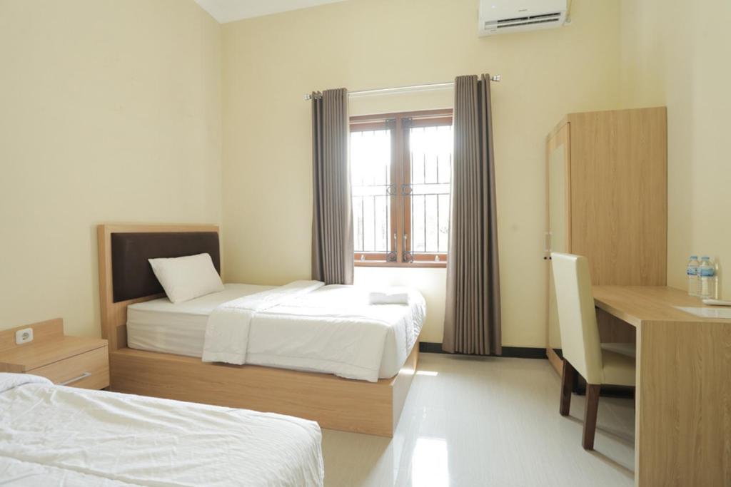 Postel nebo postele na pokoji v ubytování IDR Green Guest House Syariah Mitra RedDoorz