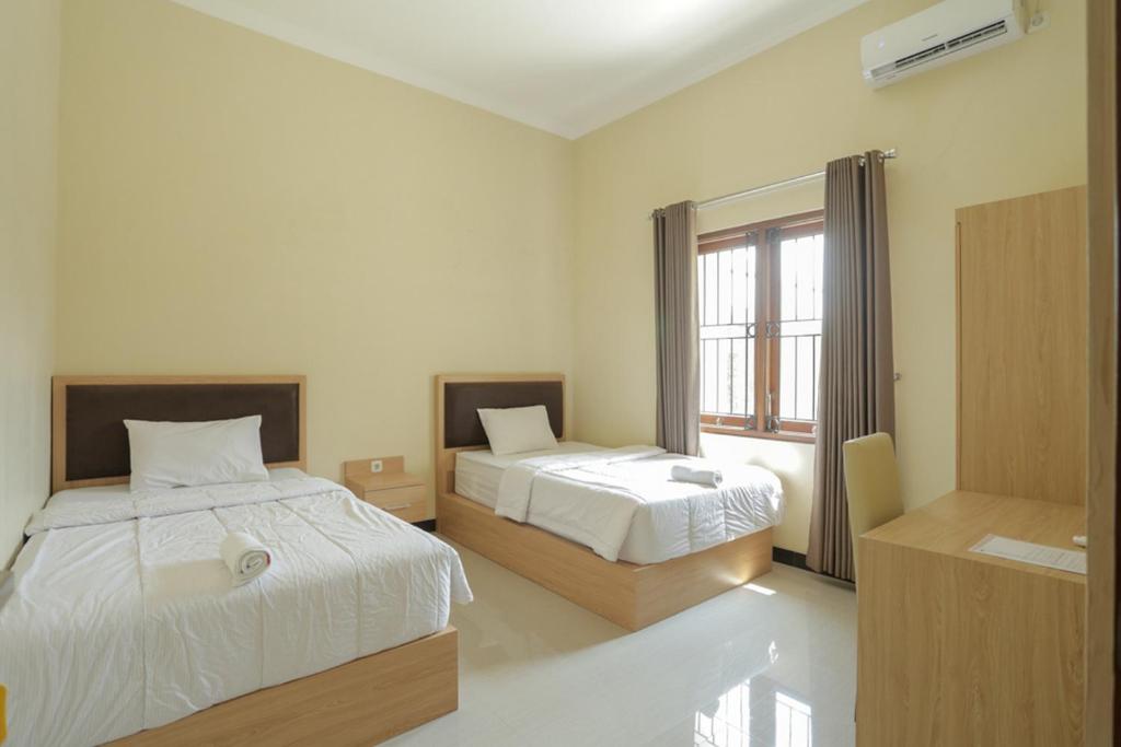 Postel nebo postele na pokoji v ubytování IDR Green Guest House Syariah Mitra RedDoorz