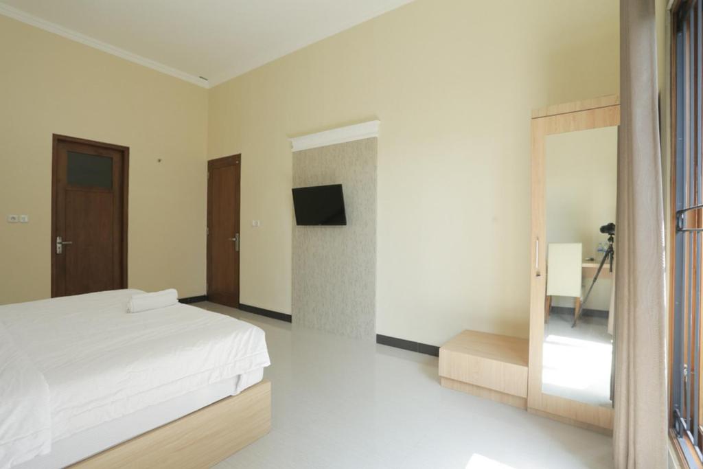 Postel nebo postele na pokoji v ubytování IDR Green Guest House Syariah Mitra RedDoorz