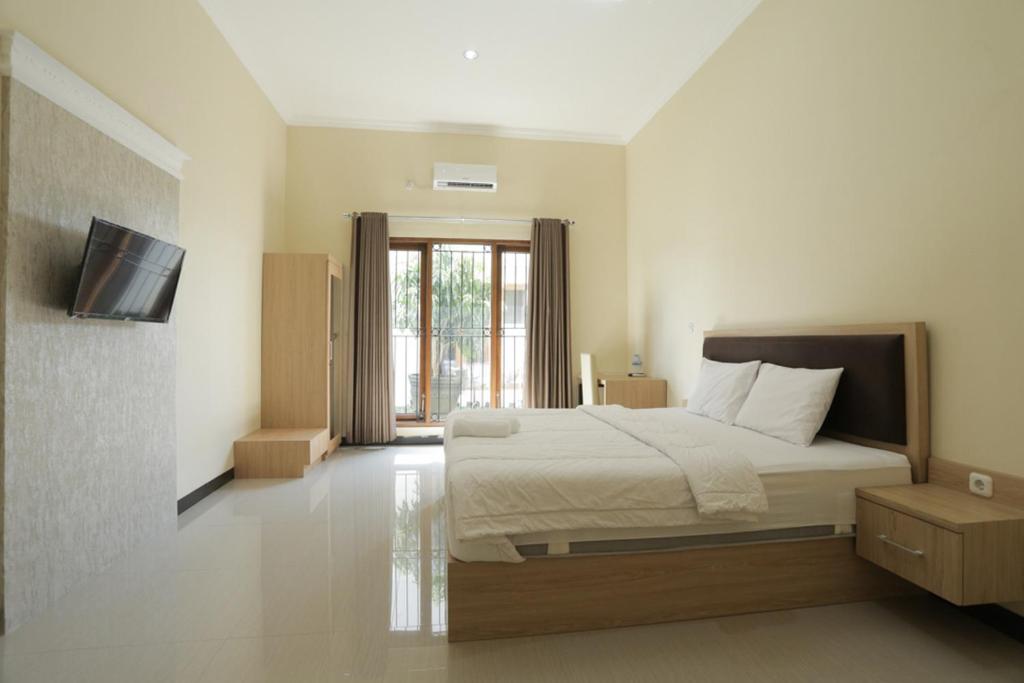 Postel nebo postele na pokoji v ubytování IDR Green Guest House Syariah Mitra RedDoorz