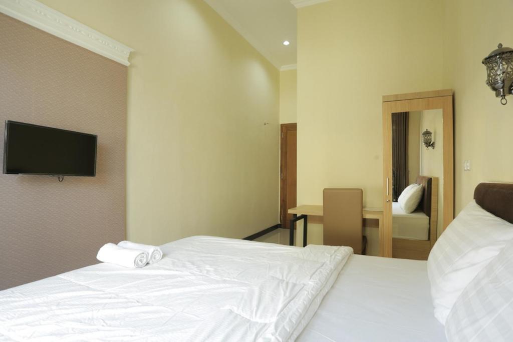 Postel nebo postele na pokoji v ubytování IDR Green Guest House Syariah Mitra RedDoorz