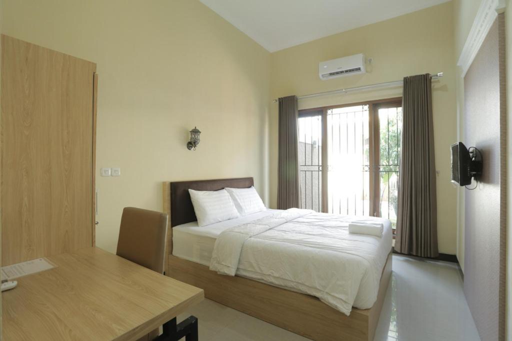 Postel nebo postele na pokoji v ubytování IDR Green Guest House Syariah Mitra RedDoorz