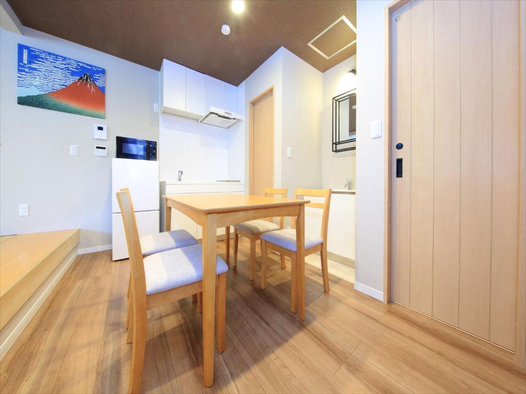 a dining room with a wooden table and chairs at COTO Tokyo Asakusa 5 in Tokyo