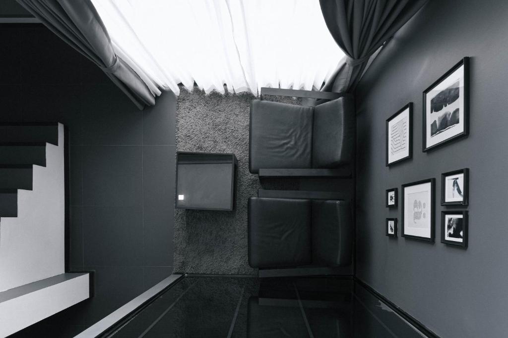 A dark, art-filled seating nook beneath a bright translucent ceiling.
