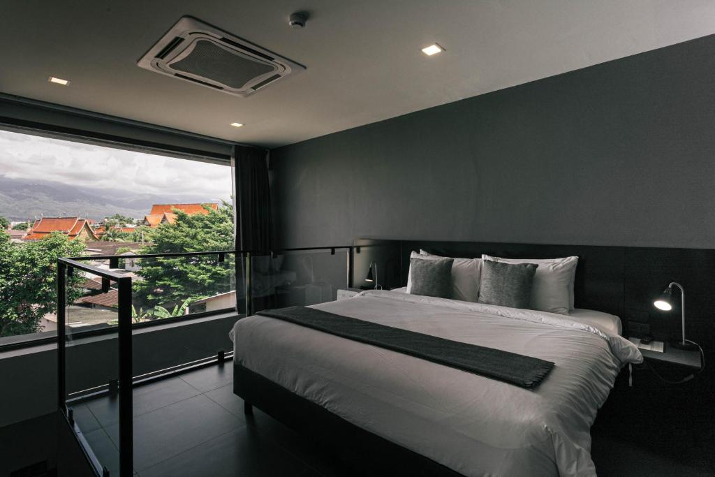 A double bedroom opening onto a balcony with a mountain-and-rooftop outlook.