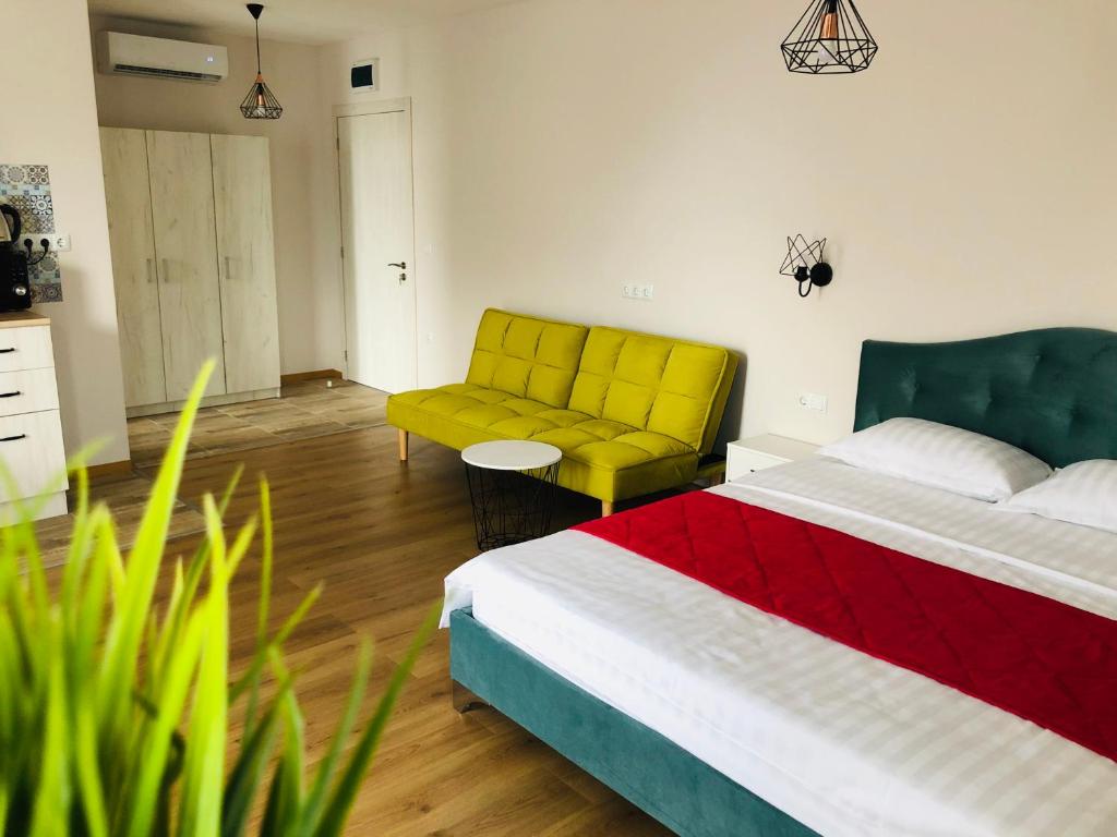 1 dormitorio con cama y sofá amarillo en Colors Boutique, en Obzor