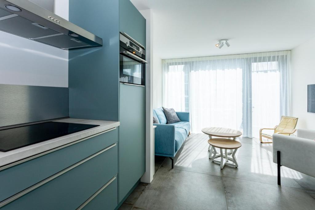 een keuken met blauwe kasten en een woonkamer bij Singel 9a in Domburg
