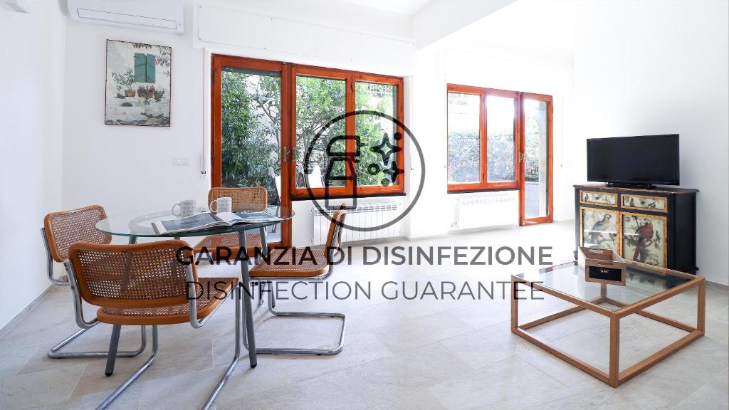 Zimmer mit einem Tisch und Stühlen sowie einem TV in der Unterkunft Italianway - Crosa dell'Oro 20 in Santa Margherita Ligure